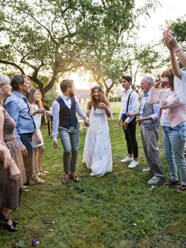 Happy newlyweds and their guests outdoors