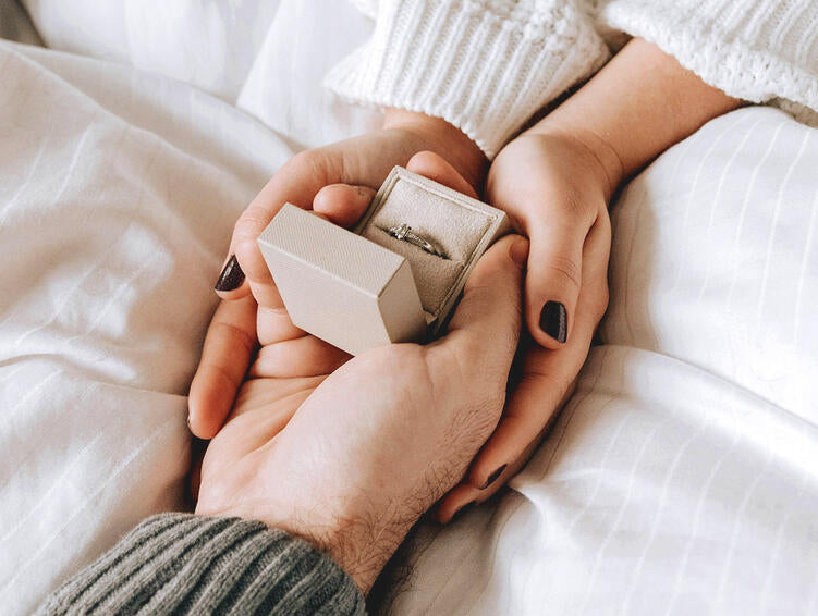 An open ring box held in two hands