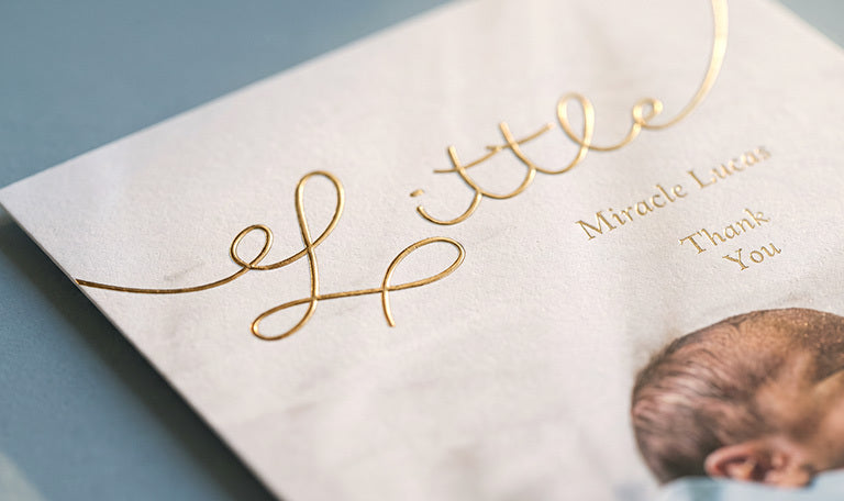 A baby thank you card with Little in gold foil lettering, close up