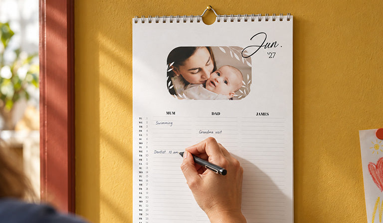 A family calendar on the wall with columns for Mum, Dad and James