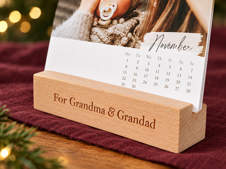 A desk calendar sheet in a wooden stand engraved For Grandma and Grandad