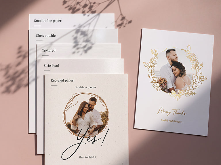 Paper samples from smooth fine paper to Sirio Pearl next to a thank you card with a gold foil wreath