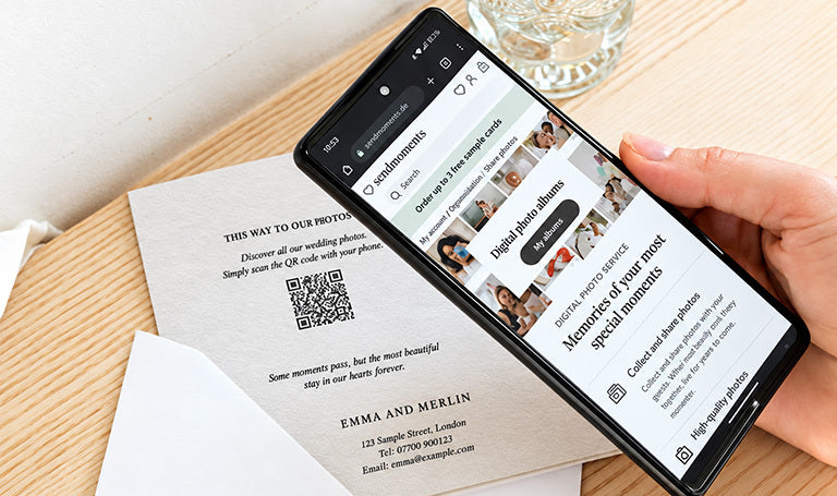Phone showing a digital photo album next to a card with a QR code on the back