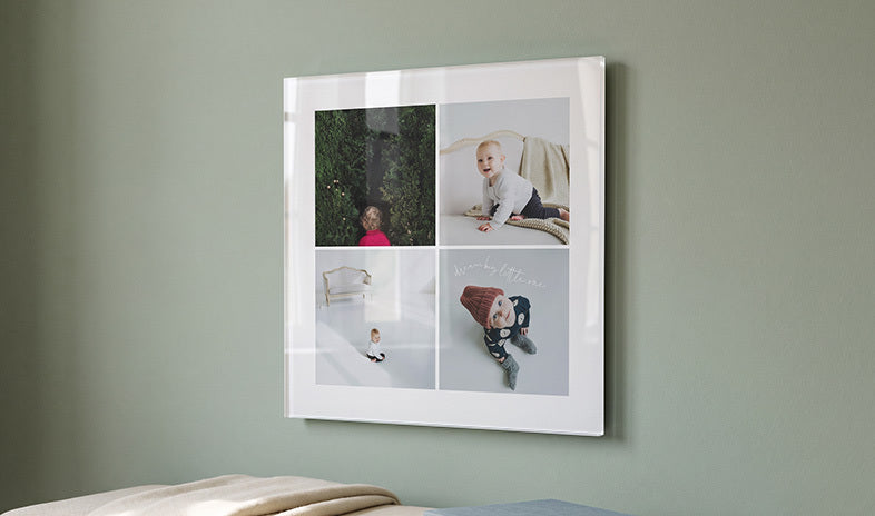 Four baby photos on acrylic glass on a green wall