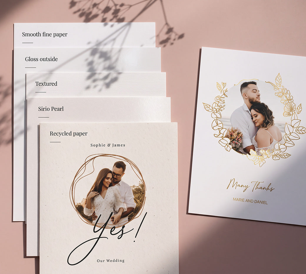 Three wedding sample cards held down by a hand with a wedding ring