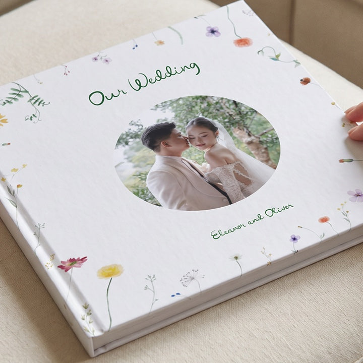 A wedding photo album with a floral cover and a round photo of the couple