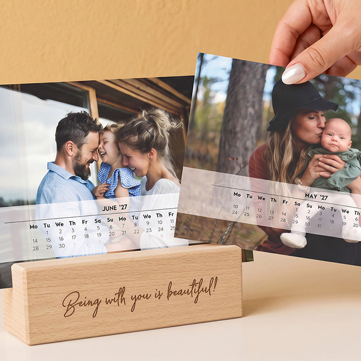 Two desk calendar pages with family photos in an engraved wooden stand